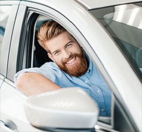 person smiling in car