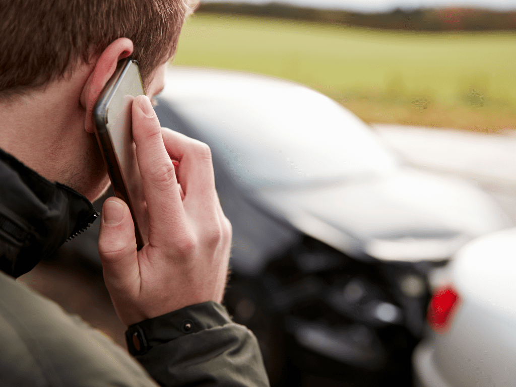 person on phone after car accident